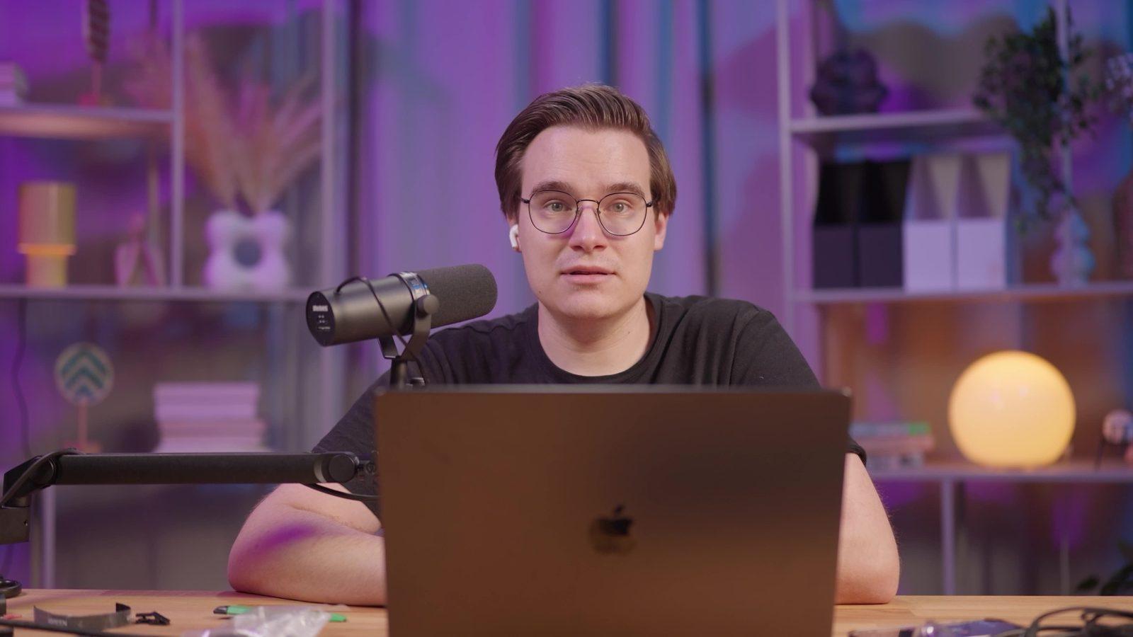 Studio solo: biurko z mikrofonem Shure i laptopem w fioletowym świetle